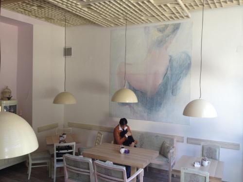 a woman sitting at a table in a restaurant at B&B Fotić in Zagreb