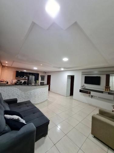 a living room with a couch and a kitchen at Casa completa Petrolina-PE in Petrolina
