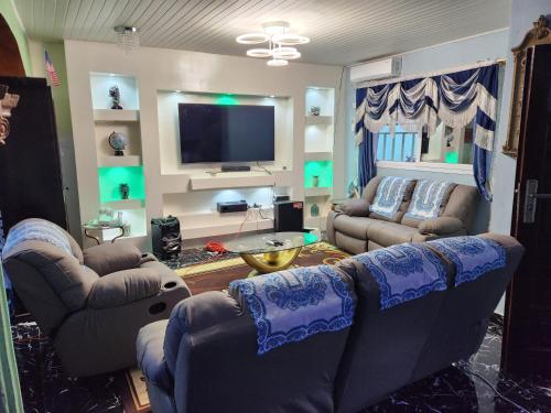 un salon avec des canapés et une télévision à écran plat dans l'établissement Cozy Flat 5 Minutes To Beach, à Freetown