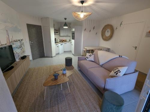 a living room with a couch and a table at Côté Phares, 4 étoiles, appartement 43 m2 Vue Mer in Les Sables-dʼOlonne