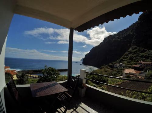 a balcony with a table and a view of the ocean at Dhamma Guest House in Ponta Delgada