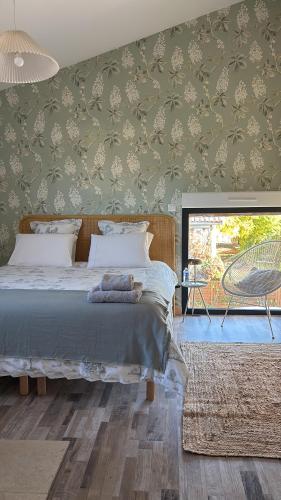 a bedroom with a bed and a large window at Chez Isa et Bruno chambres in Eymet