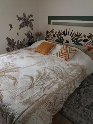 a bedroom with a bed with a white comforter at L'Amazone in Saint-Maurice-de-Beynost