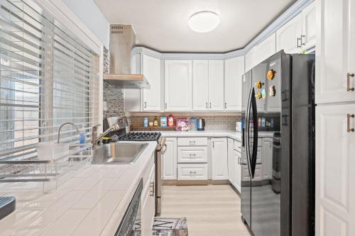 a kitchen with white cabinets and a black refrigerator at Near ONT Ontario Oasis Designer Home w Garden Park in Ontario