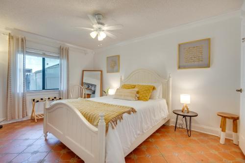 a bedroom with a white bed and a ceiling fan at 2 Blocks to Beach! Cape Canaveral Apt with Patio in Cape Canaveral