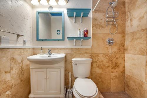a bathroom with a toilet and a sink and a mirror at 2 Blocks to Beach! Cape Canaveral Apt with Patio in Cape Canaveral