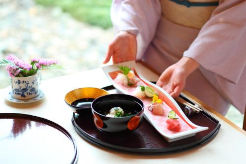 a person is eating a plate of food on a table at Hotel Okura Kobe in Kobe