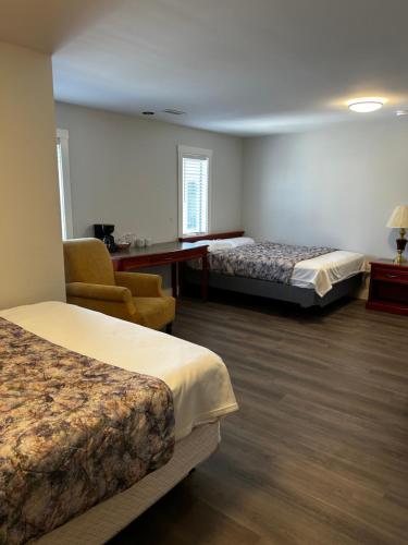 ペンティクトンにあるLakecity Innのベッド2台と椅子があるホテルの部屋
