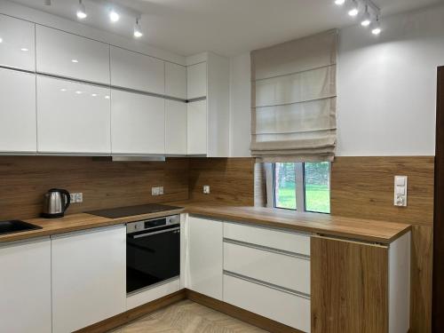 eine Küche mit weißen Schränken und einem schwarzen Gerät in der Unterkunft Agroturystyka Polanka 