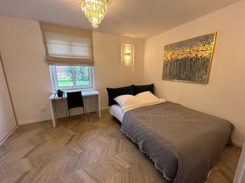 a bedroom with a bed and a desk and a window at Agroturystyka Polanka in Olesiec