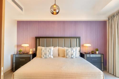 1 dormitorio con 1 cama grande, 2 mesitas de noche y 2 lámparas en Comfy Apt, Rooftop Lounge, Pool, en Ensanche Quisqueya