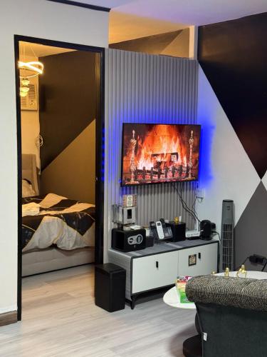 a living room with a tv on a wall at Liah's Pad in Marilao