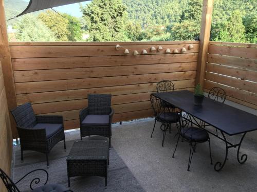 une terrasse avec des tables et des chaises ainsi qu'une grande fenêtre. dans l'établissement Château de Jouques, à Gémenos