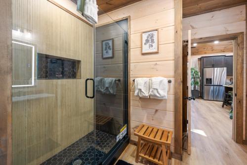 ein Badezimmer mit Dusche und einer Sitzbank darin in der Unterkunft Rustic RidgeView Hot Tub Grill Foosball More in Cove Creek Cascades