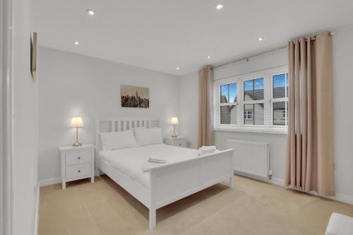 een witte slaapkamer met een wit bed en een raam bij Sunrise View - North East Escapes in Long Houghton