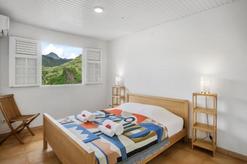 Un dormitorio con una cama con toallas. en Appartement Alizés - Vue Mer et Accès plage direct, en Le Carbet