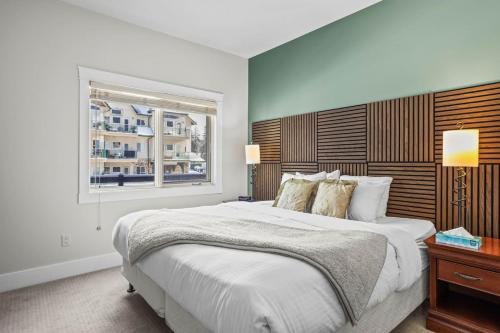 um quarto com uma cama grande e uma janela em Mountain Escape 2BR Hot tub and Pool Near Banff em Canmore
