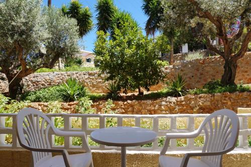 a table and two chairs and a table and chairs and trees at Vasilaras Hotel in Skala