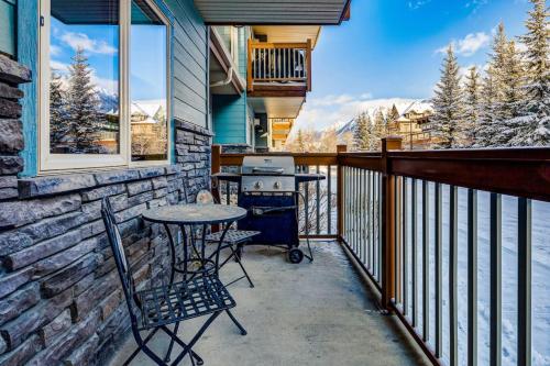 een terras met een tafel en stoelen op een balkon bij 3BR Rockies Condo Heated Pool and Hot Tub in Canmore