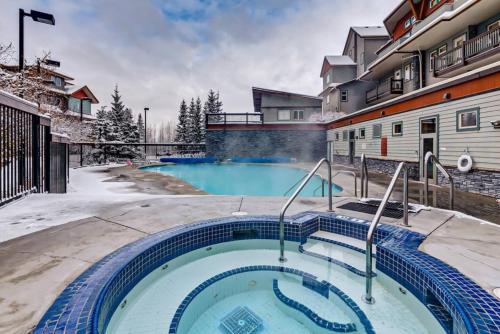 a swimming pool in the backyard of a house in the snow at Spacious Getaway near Banff with Heated Pool in Canmore