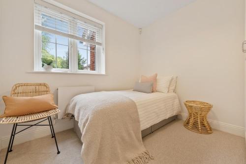 Un dormitorio con una cama, una silla y una ventana en Modern home in Sunninghill, en Ascot