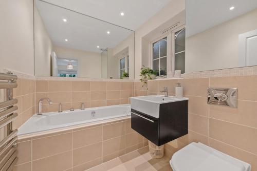 Un baño con bañera, lavabo e inodoro. en Modern home in Sunninghill, en Ascot