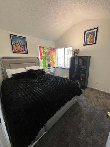 a bedroom with a bed with a black comforter at Charming room in artist studio and Gallery in Santa Clarita