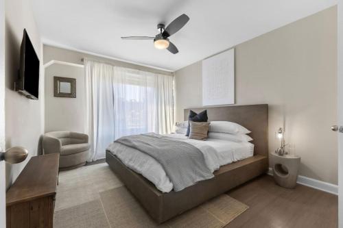 een slaapkamer met een groot bed en een stoel bij Elevated Minimalist Escape - Free Parking and Metro - The Sutton in Radnor Heights