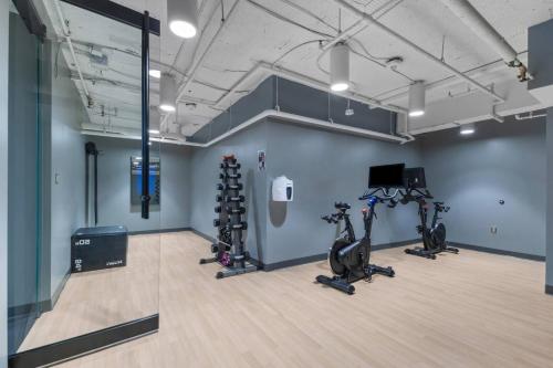 a gym with treadmills and exercise bikes in a room at The Sutton - Elevated Minimalist Escape with Free Parking and Metro in Arlington