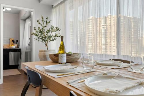 a dining room table with a bottle of wine on it at The Lexington - Serene Apartment, 5 min to DC with Free Parking and Metro in Arlington
