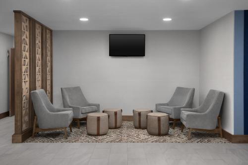 a waiting room with four chairs and a flat screen tv at Holiday Inn Express Baltimore - BWI Airport NE by IHG in Baltimore