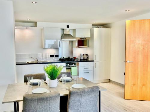 a kitchen with a table and chairs in a kitchen at Bright 2 Bed Flat with Balconies & Views in York City Centre in York