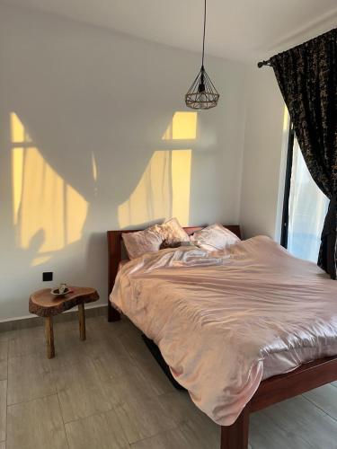 Schlafzimmer mit einem Bett mit einem Tisch und einem Fenster in der Unterkunft Kitisuru Zen Stay in Gatunga