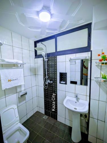 a bathroom with a shower and a toilet and a sink at KAZA City in Bafoussam