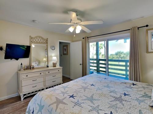 a bedroom with a bed and a ceiling fan at Lighthouse Point by Tybee Vacation Rentals in Tybee Island