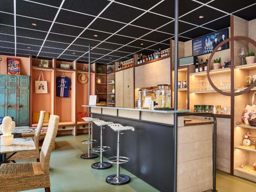 a bar in a restaurant with chairs and a table at Greet Boulogne Billancourt Paris in Boulogne-Billancourt