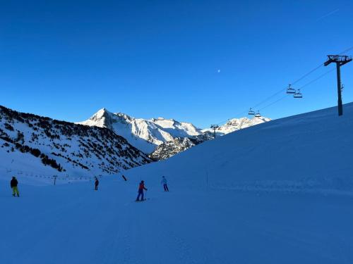 un groupe de personnes skier sur une montagne enneigée dans l'établissement Le Domaine du Lary, à Cadeilhan-Trachère