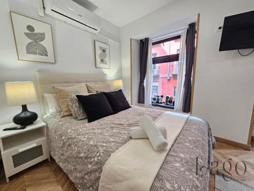 een slaapkamer met een bed met kussens en een raam bij Estudio con Wifi y AC en Centro Sol y Gran via in Madrid