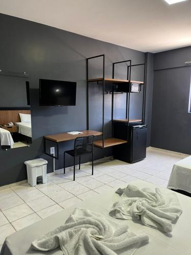 a bedroom with a desk and a bed with a blanket at Hotel Farol de Tambaú in João Pessoa