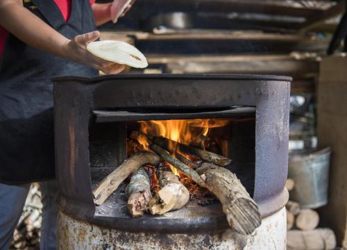 a person is cooking food over a fire at Casa Alma, Nature Escape with River, Trails and Views in San Rafael