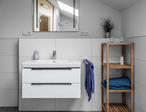 a bathroom with a sink and a mirror at Neue Liebe Haffkrug 5 - Meeresstern in Haffkrug