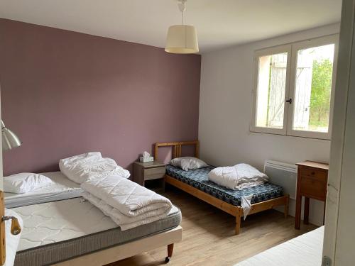 a bedroom with two beds and a window at Le Mas Mouth in Montoulieu