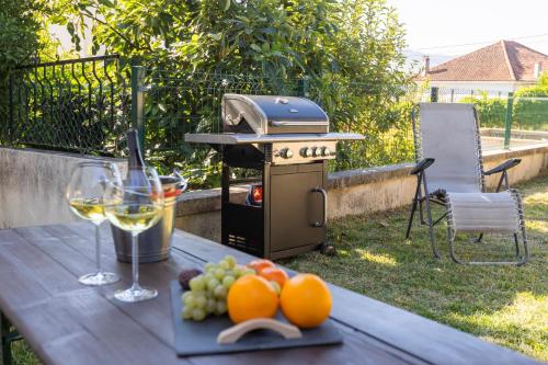a picnic table with a glass of wine and a grill at Casa de Clarisse in Ermelo