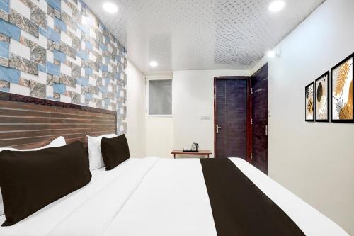 a bedroom with a white bed and a wall with tiles at Hotel O Pragati in Jairāmpura