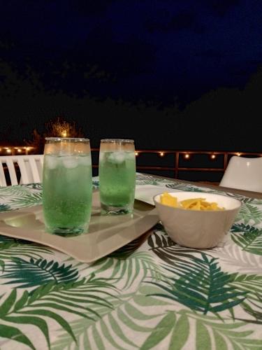 a table with two drinks and a bowl of chips at Leukos Home Relais Ecoretreat b&b in Diamante