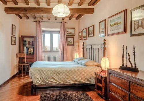 a bedroom with a bed and a desk and a window at La casa degli esposti in Anghiari