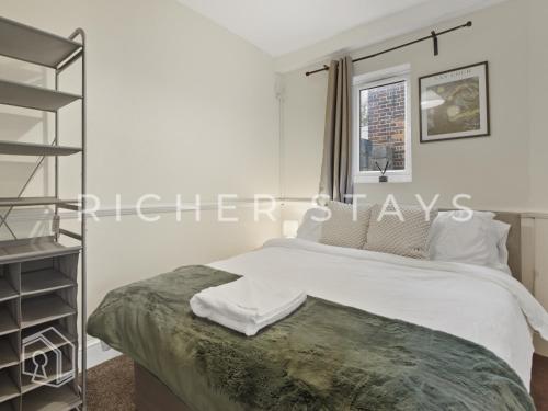 ein Schlafzimmer mit einem Bett und einem Bücherregal in der Unterkunft Spacious 3BR House in Tilbury, Driveway and Garden in Tilbury