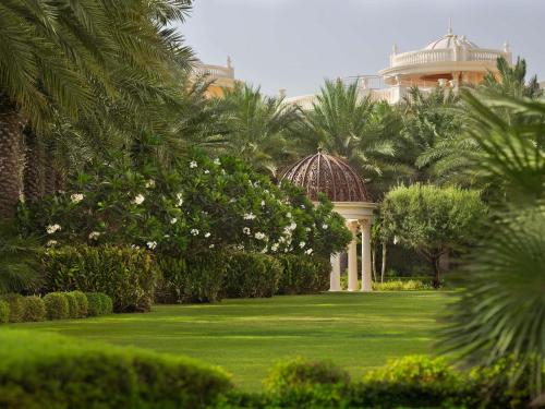 d'un jardin avec un kiosque et des palmiers. dans l'établissement Raffles The Palm, à Dubaï