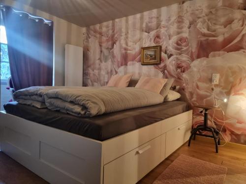 1 dormitorio con 1 cama con pared de flores en La Nit de la Fontaine, en Brossac