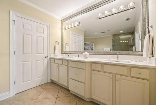 a bathroom with two sinks and a large mirror at Resort-style Elegance in Blue Gulf Beach